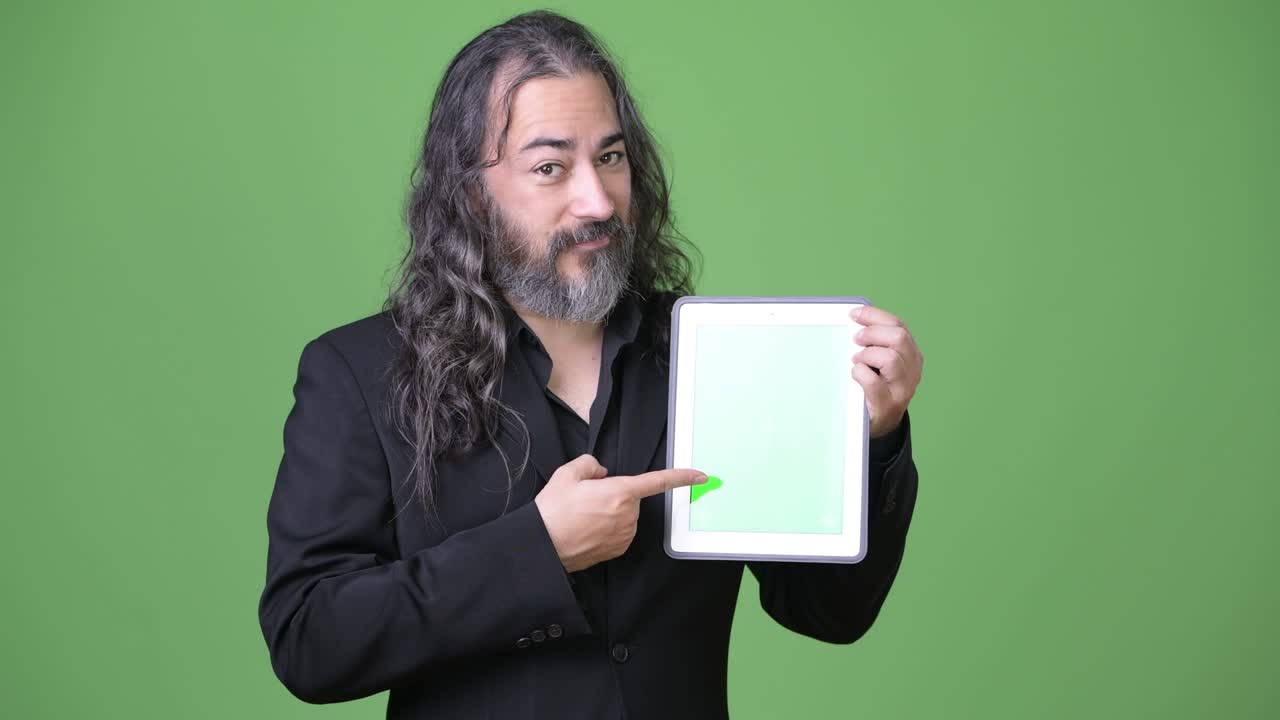 성숙하고 잘생긴 수염이 있고 긴 머리카락을 가진 다민족 사업가입니다.