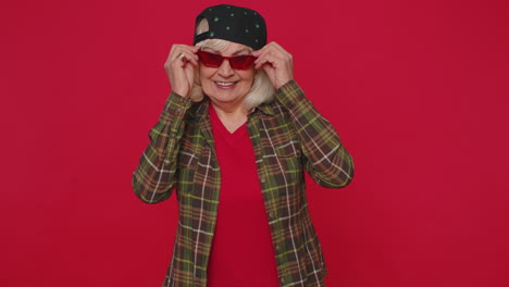 seductive cheerful stylish senior old woman wearing sunglasses, charming smile, blinks winks eyes