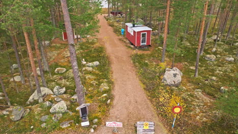 Casas-De-Madera-Rojas-En-El-Bosque-Cerca-Del-Lago-En-Suecia---Toma-Aérea