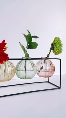 colorful glass vase arrangement on a black metal stand