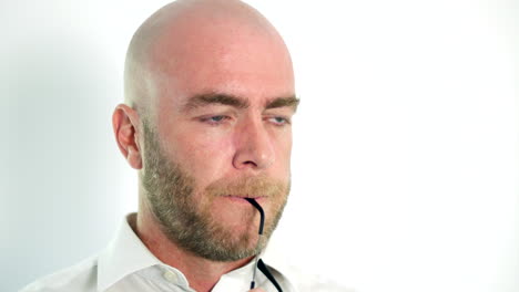 Pensive-man-chewing-on-glasses-deep-in-thought-on-white-background