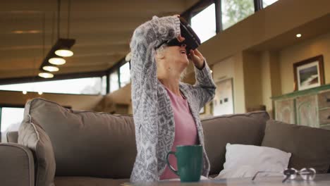 Ältere-Frau-Mit-Gemischter-Abstammung-Sitzt-Auf-Dem-Sofa-Und-Trägt-Ein-VR-Headset