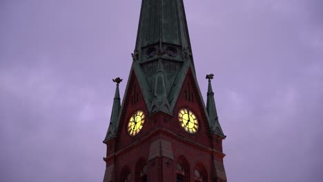 Crows-and-ravens-flying-around-old-church-tower-with-clouds-passing-in-background---Trinity-church-Arendal-Norway---Handheld-static-moody-dark