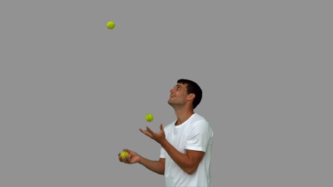 man dribbling with balls on grey screen