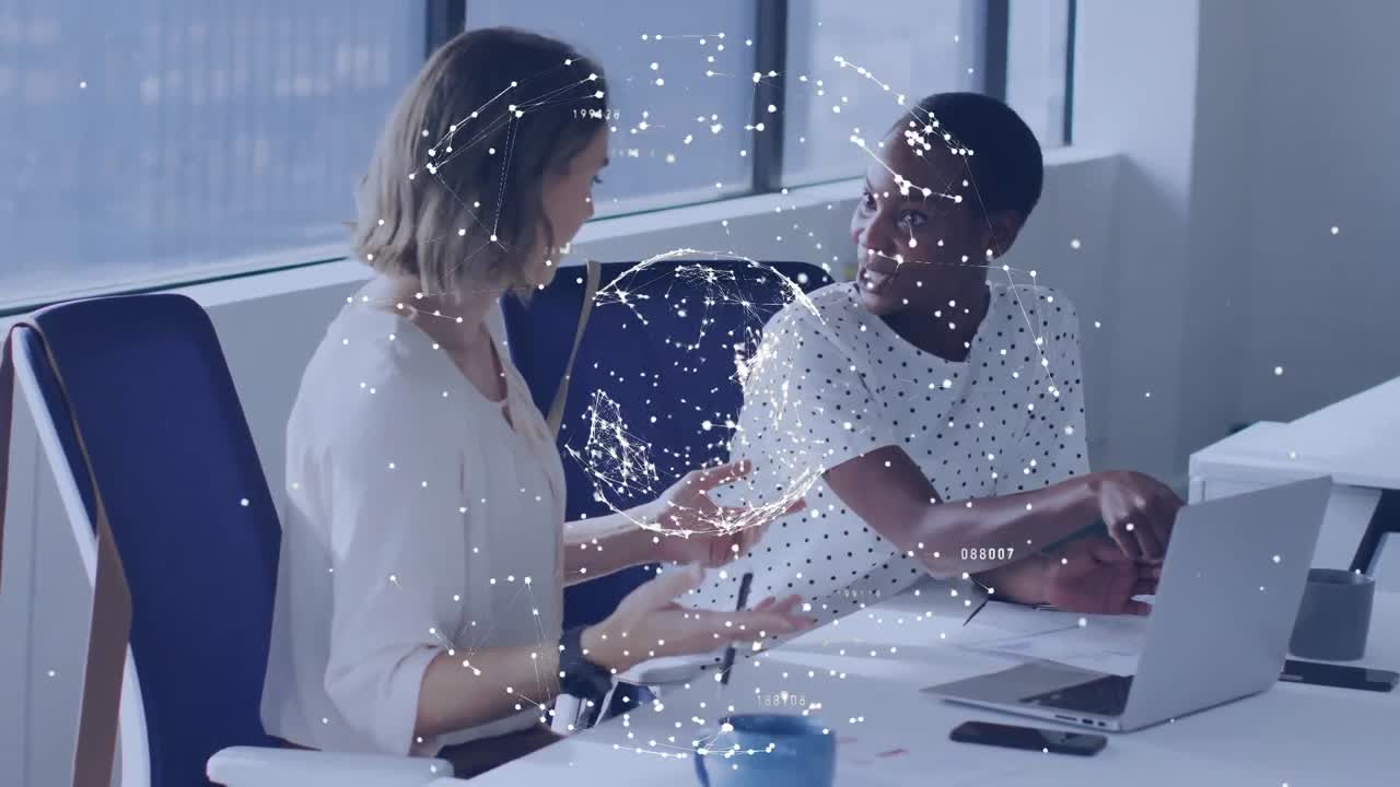 Animation of globe of network of connections over two diverse women discussing at office