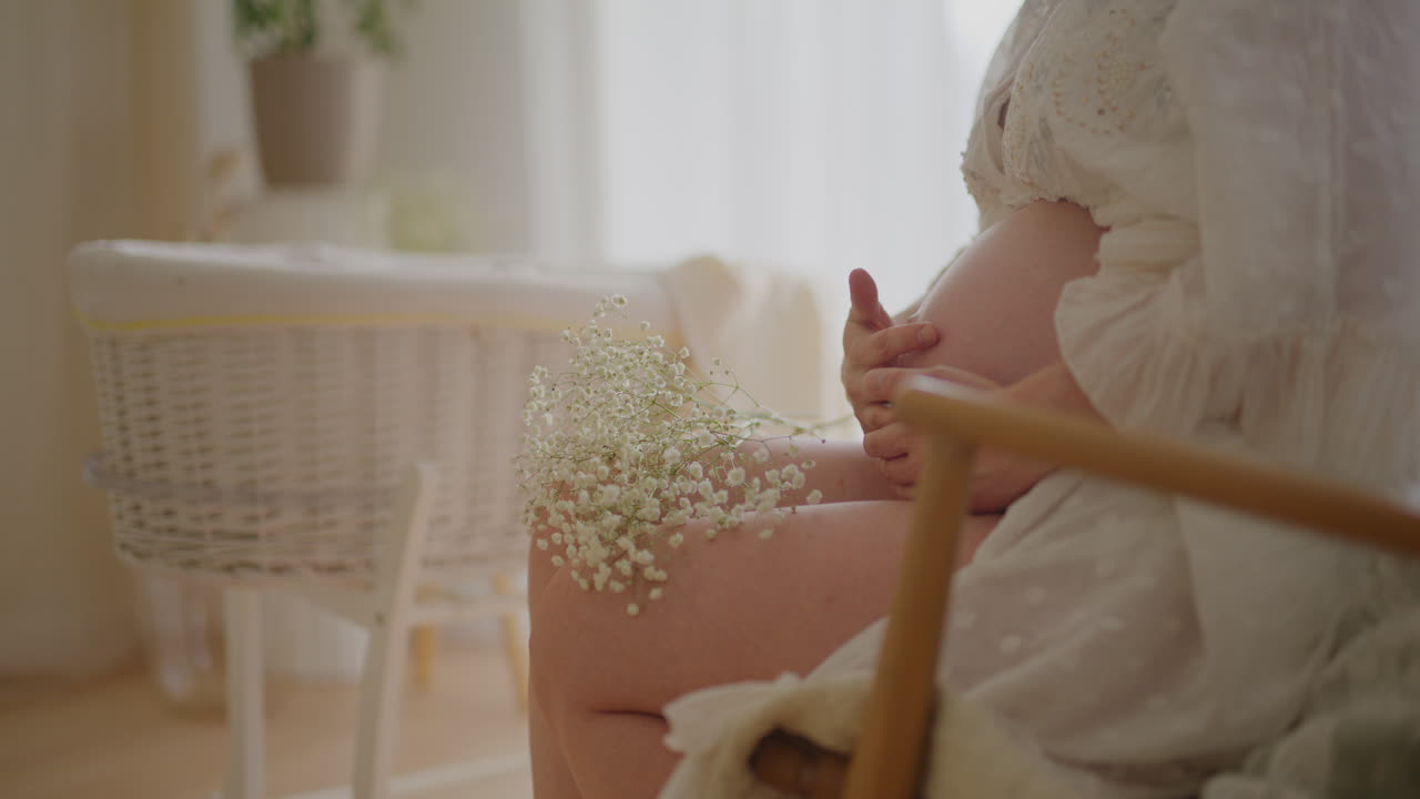 Pregnant Woman Cradles Baby in Nursery