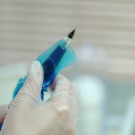 a cosmetologist is preparing a professional brush with a needle for the procedure of permanent makeup of eyes. modern cosmetology. beauty salon