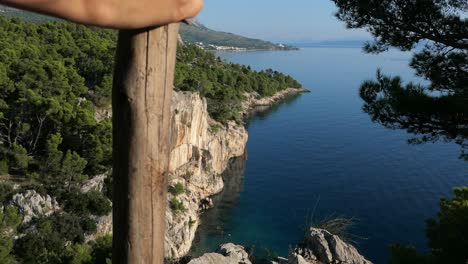 hiker on top of cliff with unspoiled mediterranean coastline mountain sea view