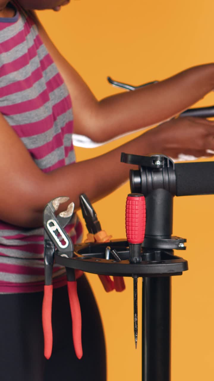 Vertical video Mechanic utilizing different tools to repair damaged bike handlebar grips,