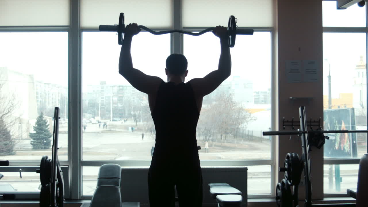 The Man The Weightlifter Lifts a Barbell In a Gym (Stock Footage)