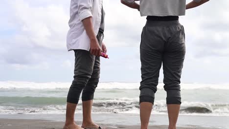 slow motion of young carefree couple is having fun and enjoying their summer vacation together on a beach with a sea in a sunny day