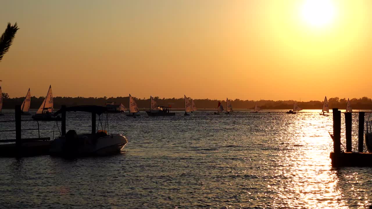 pequeña regata de veleros durante una increíble puesta de sol en el río cape fear