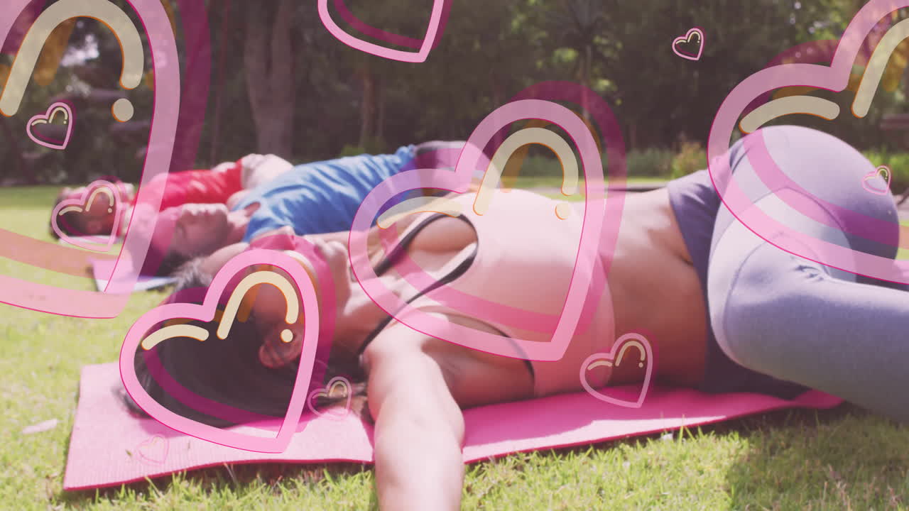 People relaxing on yoga mats with heart animations overlaying scene