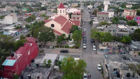 Touring-the-streets-of-a-mexican-town-by-air,-and-in-the-middle-of-it,-a-colourful-church