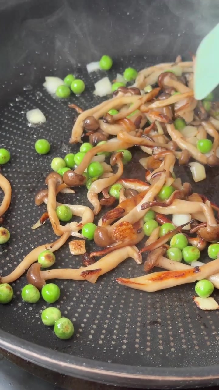 Salteando champiñones y guisantes en una sartén antiadherente