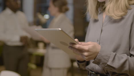 close-up van een onherkenbare vrouw die een tablet gebruikt op kantoor