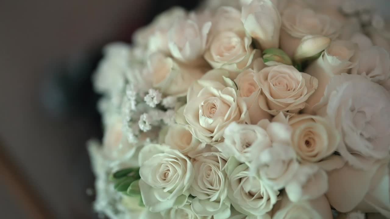 Una macrofotografia ravvicinata cattura la delicata bellezza di un bouquet da sposa, fungendo da elemento di transizione delicato e romantico per una sequenza di matrimonio, ripresa con slow motion