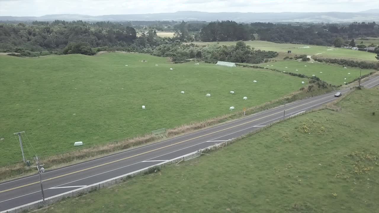 Aerial view of a road passing through a farm with hay bales
