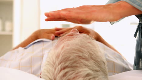 un anciano en terapia de reiki.