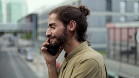 Smiling-man-talking-by-smartphone