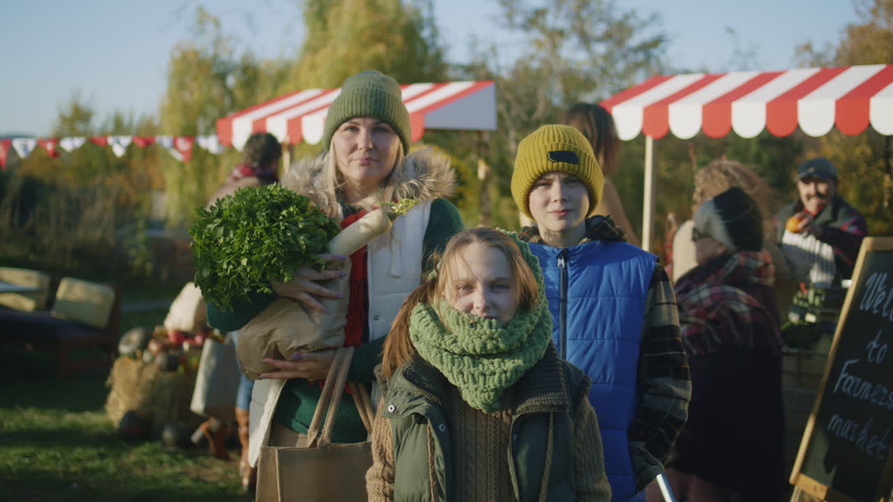 Family shopping for fresh produce at an outdoor farmers market