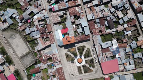 Aerial flyover looks directly down onto Cajatambo Plaza in Peru mtns