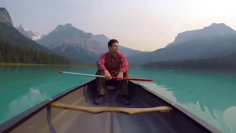 hombre sentado en un barco en el lago 4k