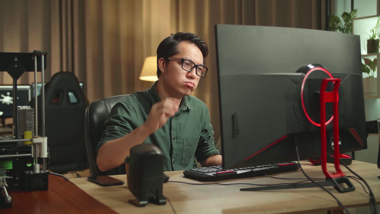 Frustrated Asian Man Works On Personal Computer And 3D Printer In Home Office, He Works At Night