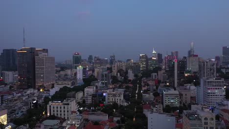 Ho-Chi-Minh-City,-Saigon,-Vietnam-evening-aerial-panning-shot-across-key-buildings-of-skyline-under-lights