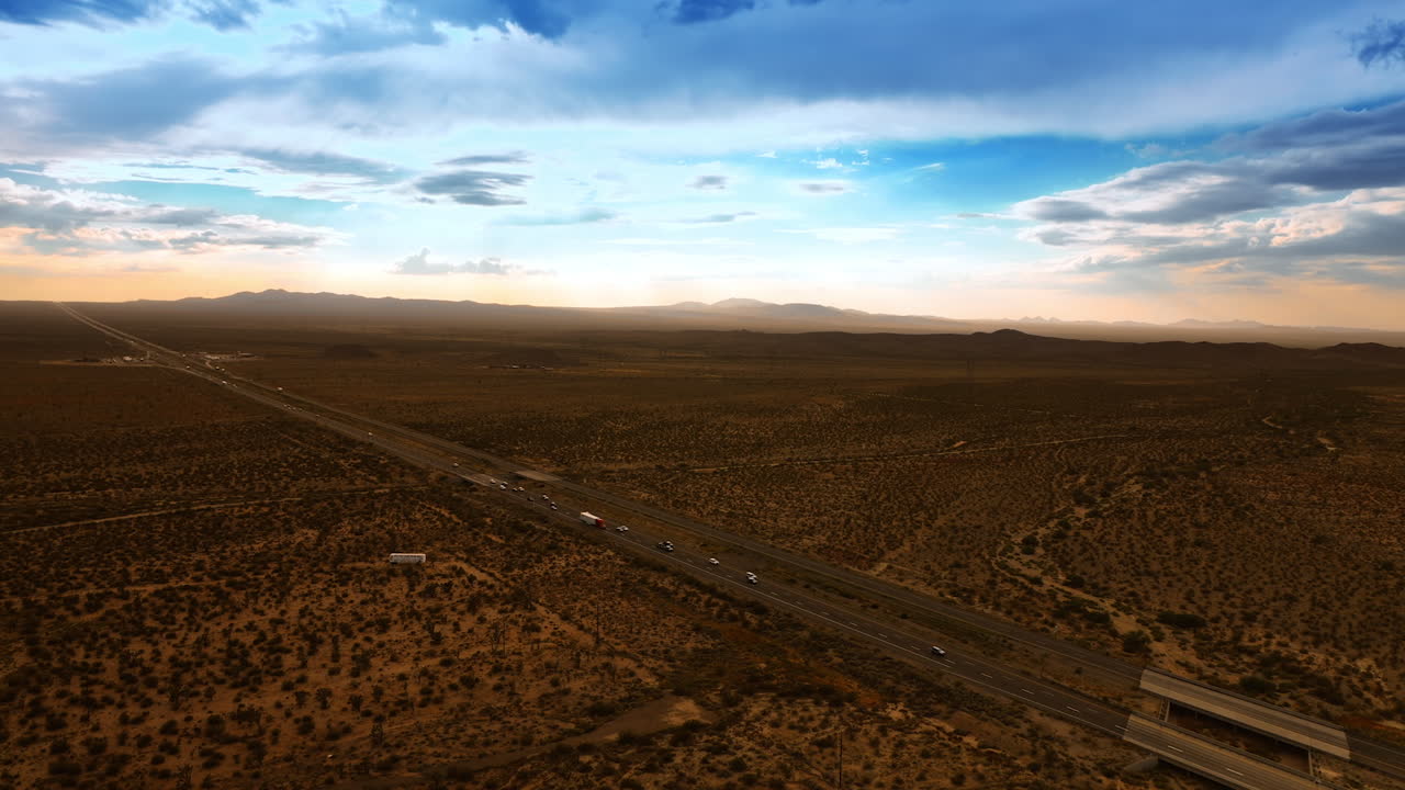 Scenery of Death Valley after sunset. Cars run by the speedway. Blue sky with clouds at backdrop. Aerial view.