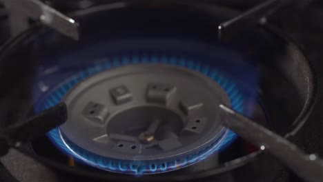 a sparkle ignites a gas stove burner in a kitchen, creating blue flames