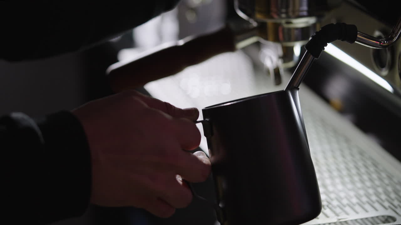 커피 음료 를 위해 바리스타 가 증기 를 내는 우유