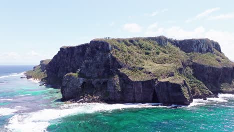 Aerial-wide-shot-of-Cabo-Samana-Cave-Island-with-splashing-water-of-Caribbean-Sea-in-sunlight---Panorama-view