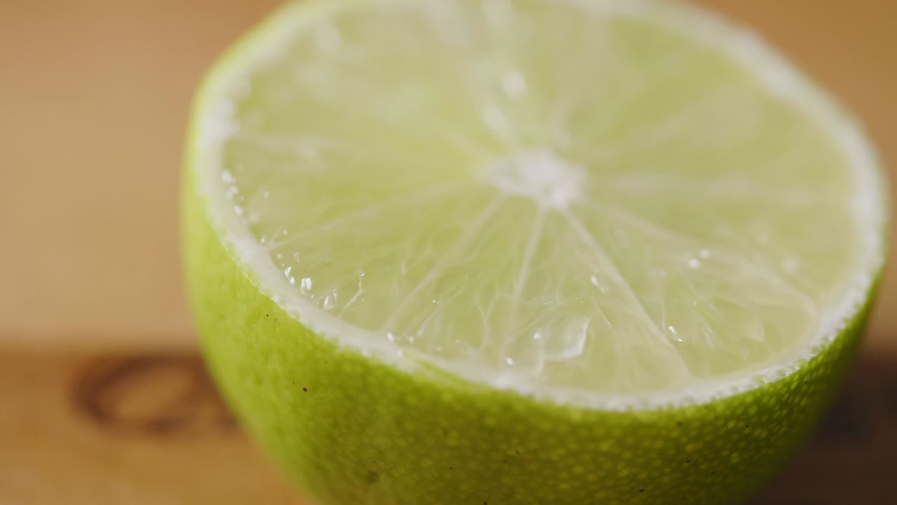 primer plano extremo de una rebanada de cal fresca girando sobre la mesa