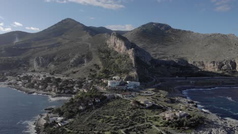 aerial retreats to sea, revealing green park on rocky point in palermo