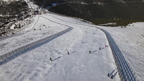 aerial view of a group of people descending a hill practicing skiing, in the navacerrada ski station, madrid, spain