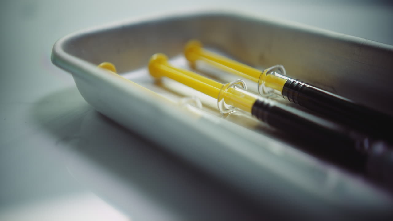 Syringes with a dark liquid on a medical tray