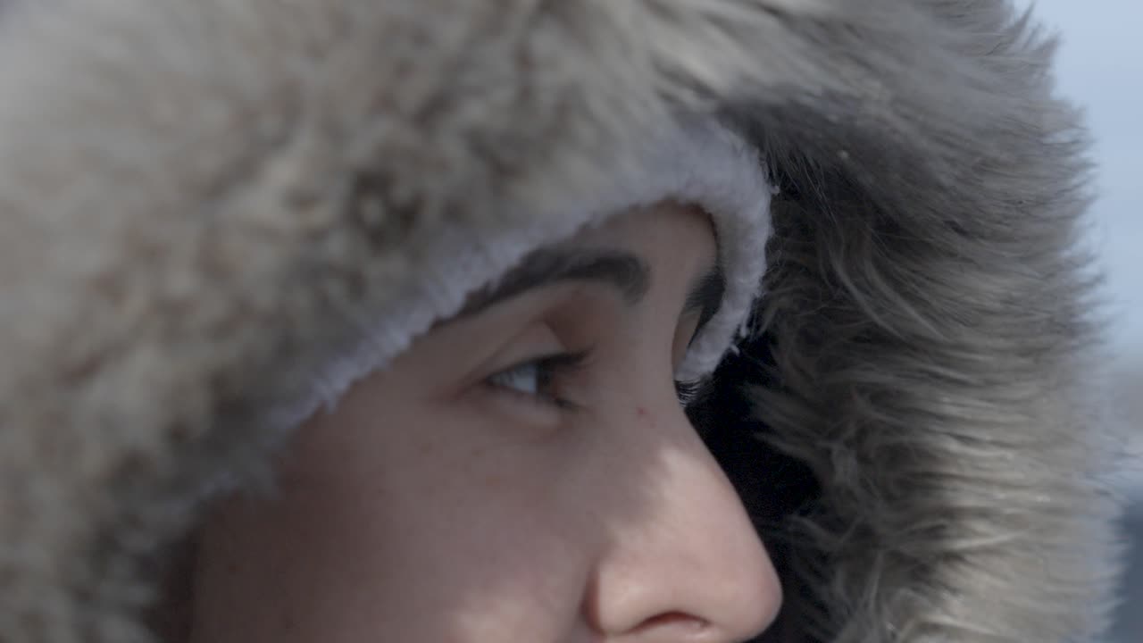 Close-up of woman in fur hood in Iceland, chill in a wanderer's eyes