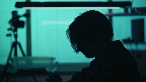 Close up Silhouette Video of a Suspect Offender Perpetrator or Prisoner Sitting in the Interrogation Close up Silhouette Video of a Suspect Offender Perpetrator or Prisoner Sitting in the Interrogation Room he is Studying the Evidence in front of him True Crime Documentary Creative Content