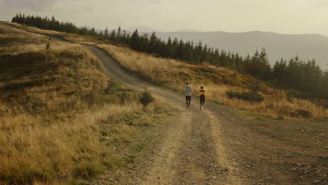 Sportsman-and-sportswoman-jogging-in-mountains.-Young-couple-exercising-outdoor