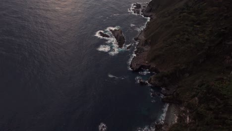 Japanese-cliffs-and-ocean-sunshine-view-in-Kyoto-beach-Kyotango-Top-down-aerial-view-of-coastline-in-Japan,-Asian-summer,-travel-destination,-slow-motion-hills-and-blue-sea