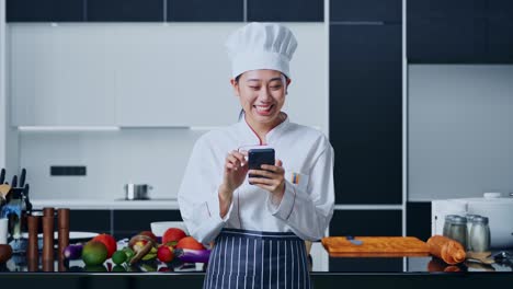 chef usando un teléfono inteligente en una cocina