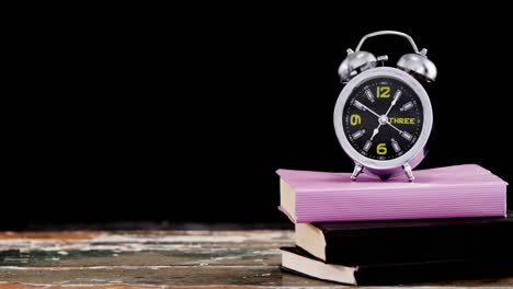 alarm clock on book stack