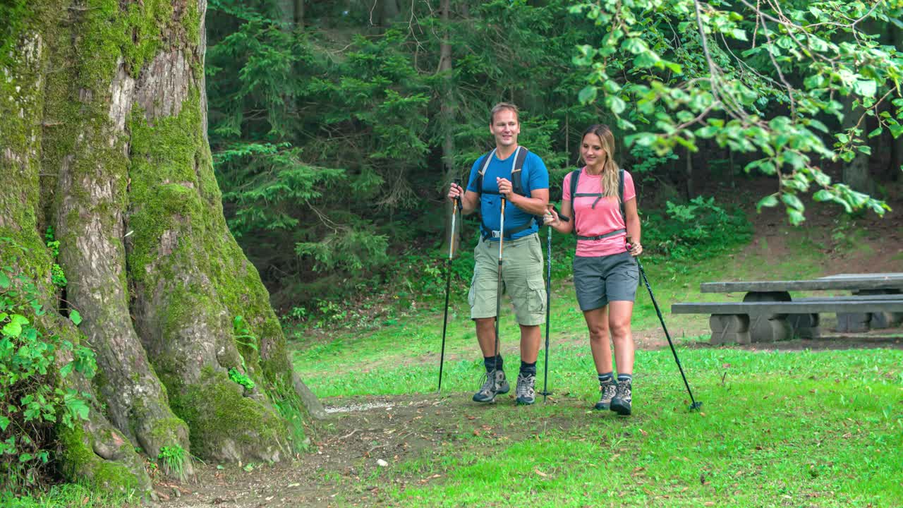 Trekking couple on a hiking trip, visiting a Najevska Linden Tree in Slovenia