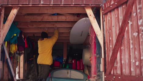 hombre obteniendo barrena de hielo de almacenamiento de madera