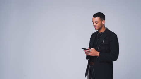 Studio-Shot-Of-Man-Against-White-Background-Sending-Text-Message-On-Mobile-Phone-In-Slow-Motion