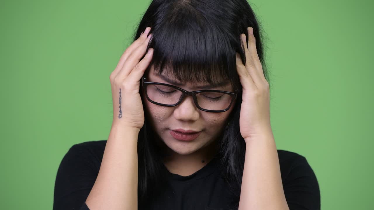 Beautiful Asian businesswoman having headache
