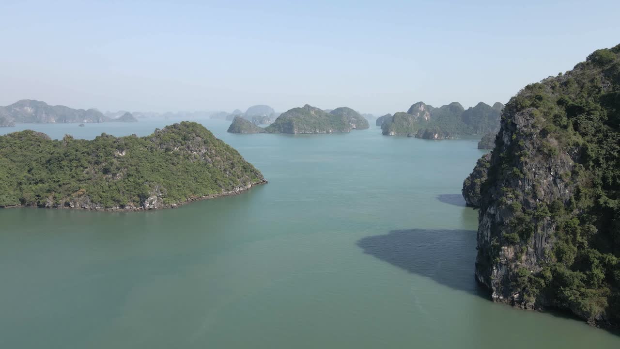 moscas aéreas bajas en medio de islas rocosas escarpadas de la bahía de ha long en vietnam