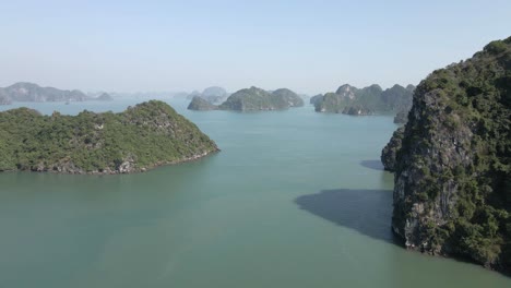 low aerial flies amid steep rocky islnds of ha long bay in vietnam