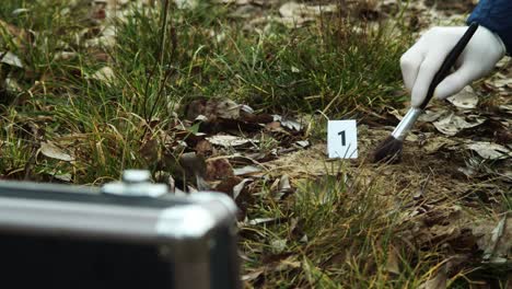 crime scene evidence, bullet in dust and case in foreground, closeup view